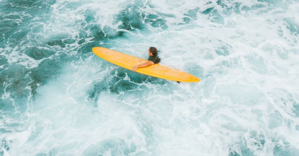 Ocean Currents - Man with a Yellow Surfboard in Rough Turquoise Water